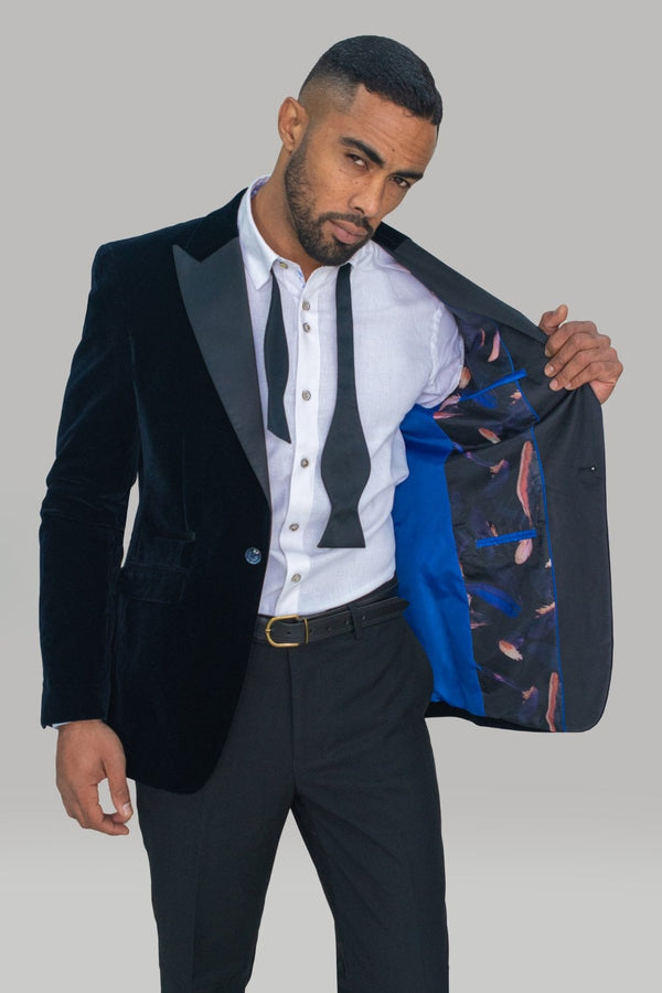 Make way for the Rosa Blazer in a beautiful navy velvet from Cavani. When you need to make a statement, then look no further than this new addition to our collection.  Also available - Black Satin Bow Tie. Style Rosa Blazer Material 100% Polyester Colour Navy Fitting Slim Fit Buttons 2 Internal pockets 2 Vents 1 Lapel Pin No