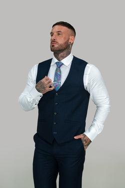 Celebrate in this tailored and sophisticated piece with its subtle check details, the stylish Seeba waistcoat is perfect to sharpen up your look.   Style Seeba Material 80% Polyester 20% Rayon Colour Navy Fitting Slim Fit Buttons 5 Internal pockets 0 Vents 0 Lapel Pin NO - Party Wear :- Office Wear