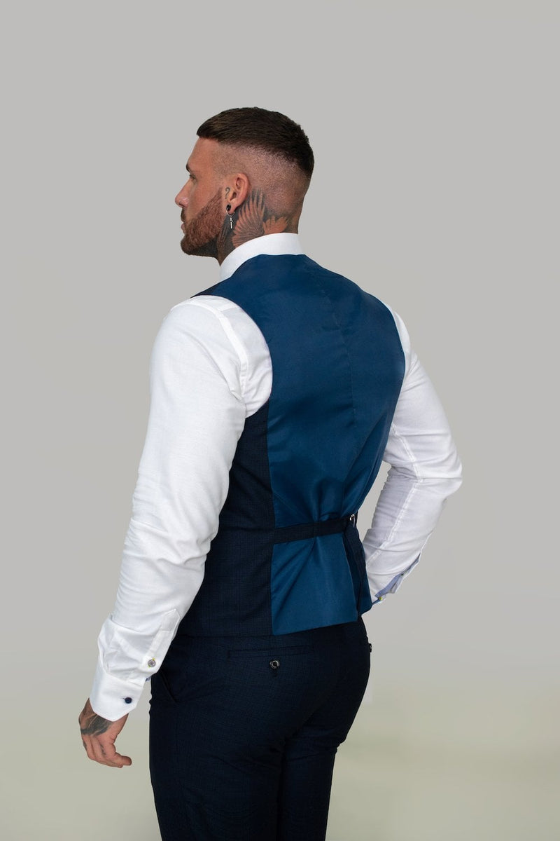 Celebrate in this tailored and sophisticated piece with its subtle check details, the stylish Seeba waistcoat is perfect to sharpen up your look.   Style Seeba Material 80% Polyester 20% Rayon Colour Navy Fitting Slim Fit Buttons 5 Internal pockets 0 Vents 0 Lapel Pin NO - Party Wear | Office Wear